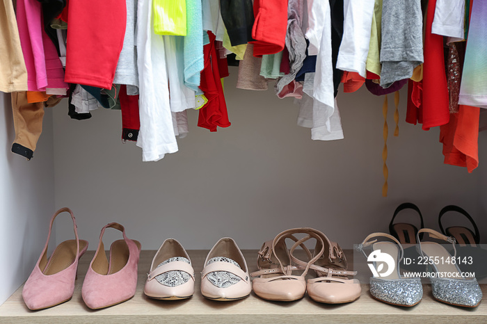 Modern wardrobe with clean clothes and shoes