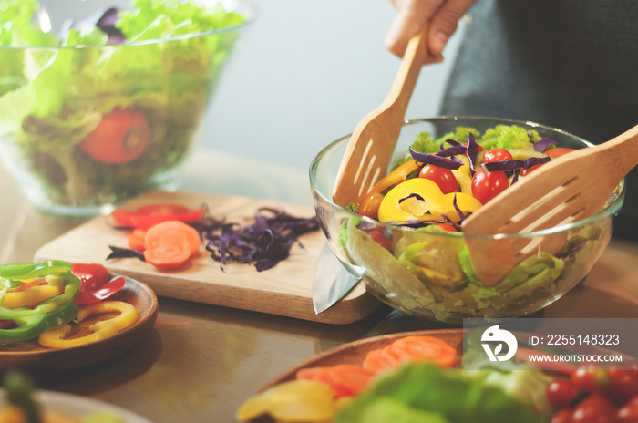 Woman cooking salad with vegetables.