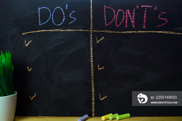 Do’s or Don’ts written with color chalk concept on the blackboard