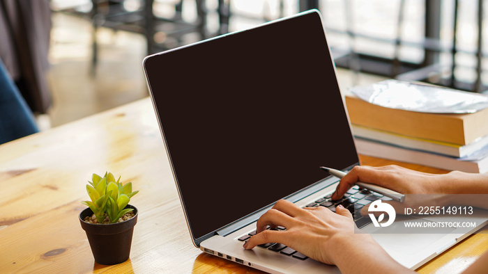 Businessman’s hand is typing a message, sending e-mails on laptop notebooks at their desks in the office online.