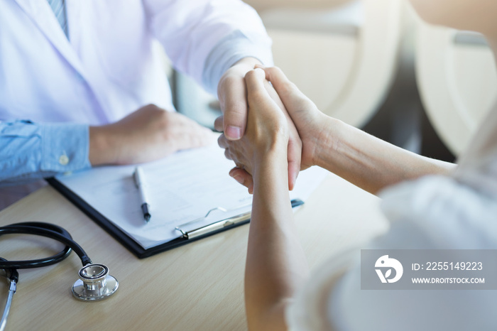 Male doctor in white coat shaking hand to female colleague