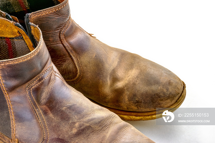 Old brown leather shoes isolated on white background with copy space. Dirty, dusty, weathered and worn out boots.