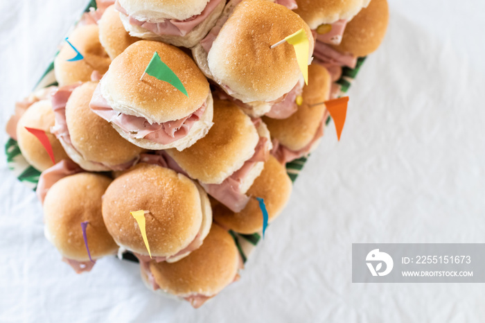 Italian party panini piled in stack in finger food style. Small panini sandwich with ham and salami. Italian food birthday party with flag. Happy food italian catering banquet with prosciutto