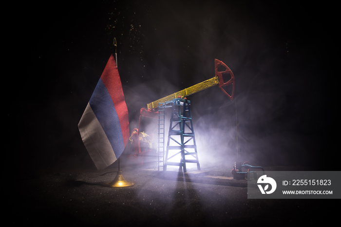 Business dialogue, oil agreement concept: National flags with Oil pump and oil refining factory at night with fog and backlight. Energy industrial concept.