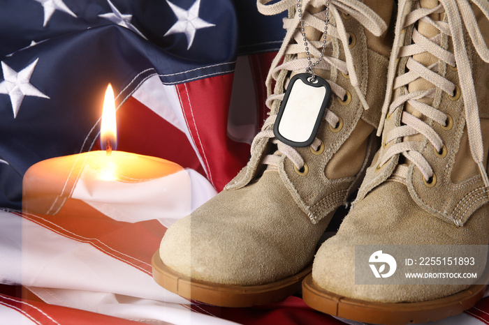 Double exposure of burning candle, military boots with tag and USA flag. Memorial Day