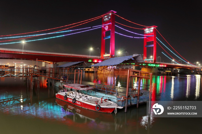 Palembang’s Ampera bridge is photographed at night, with natural lighting and slow speed photography techniques.