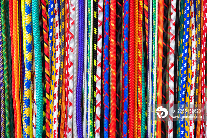 Background of bright colored wires. Wire in a variety of braids. Wires in decorative fabric braid. Many cords of different colors. Bright background.