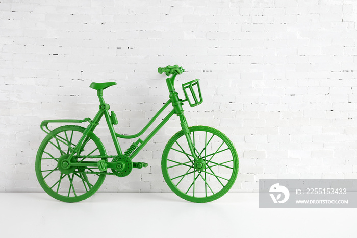 World bicycle day concept. Green bicykle on white brick wall. 3 june.