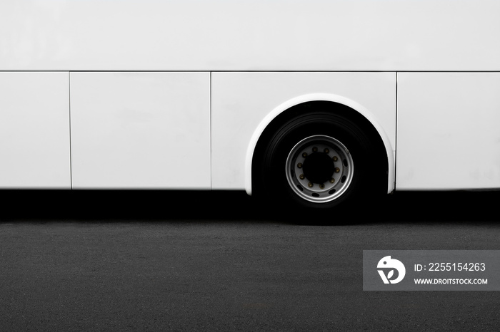 Side view of a white bus wheel on an asphalt road. - copy space for background.