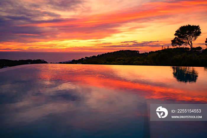 Coucher de soleil au bord de la piscine à débordement