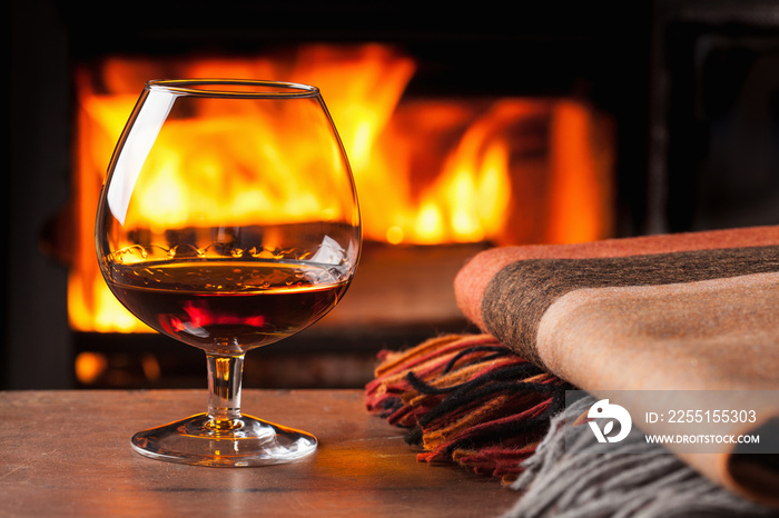 glass of cognac in front of fireplace