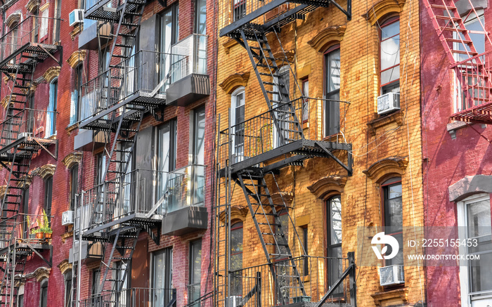 Colourful red and yellow brick buildings with fire stairs on a sunny day. Brooklyn. NYC, USA