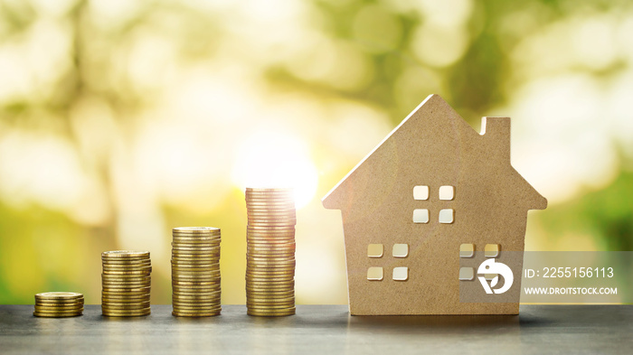 House Model and Golden Coins Stacks with blur Background.Savings Plans for Housing,Finance and Banking about House concept.