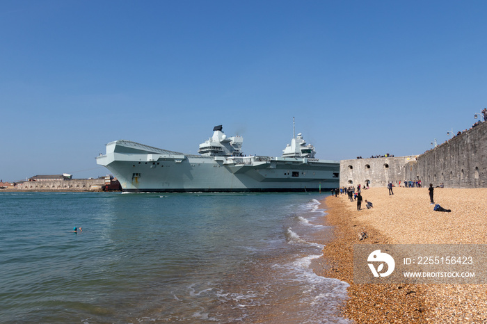 HMS queen Elizabeth leaving Portsmouth Harbour with people gathering to watch as it passes the round tower