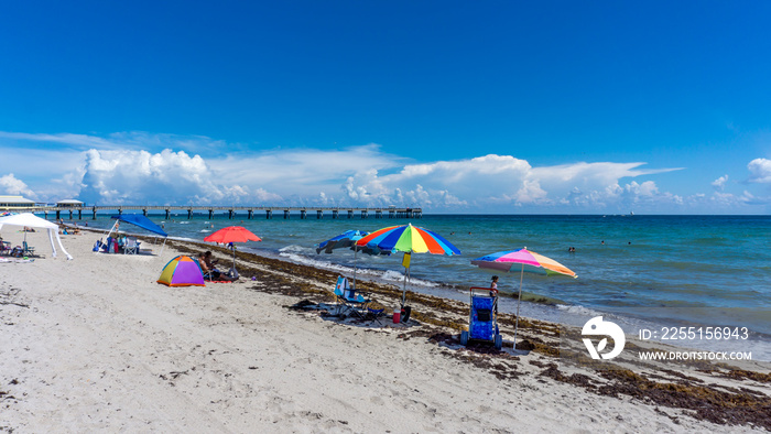 Pier of Dania beach in Hollywood, Florida. People enjoying their vacation and swimming in the beach in summer