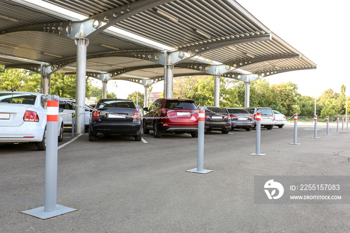 Limiters with red and white stripes on parking under canopy