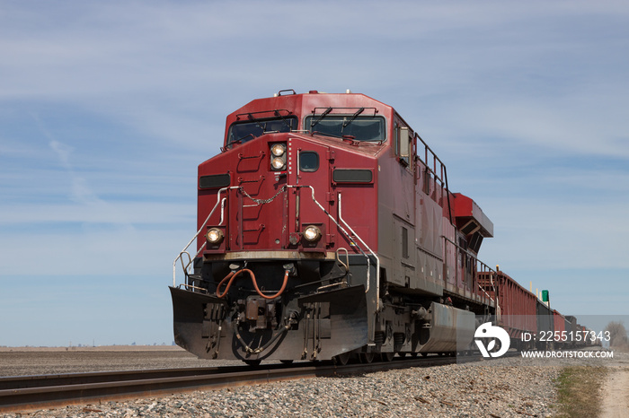 Big Red Locomotive Leading Freight Train on Prairie