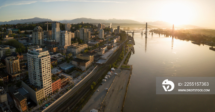 Aerial Panoramic view of Fraser River and Bridges during a vibrant sunrise. Taken in New Westminster, Greater Vancouver, British Columbia, Canada.