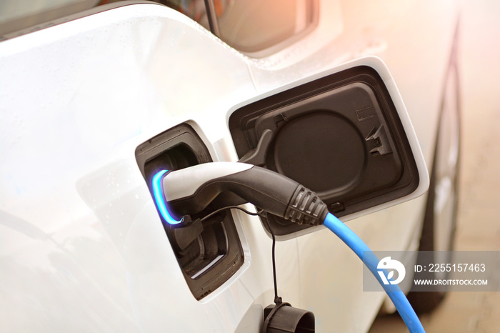 The process of charging of an electric car with a socket. Vehicle charger close up.