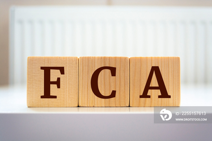 The word  FCA  written on wood cube. FCA - short for Financial Conduct Authority