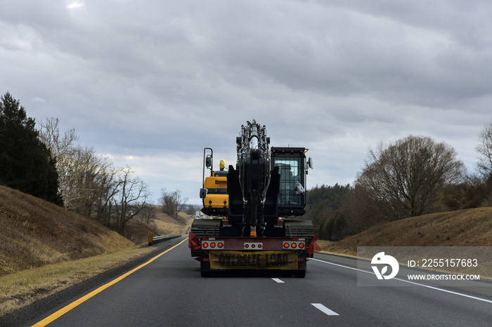 Carrying heavy construction equipment a trailer platform on the highway