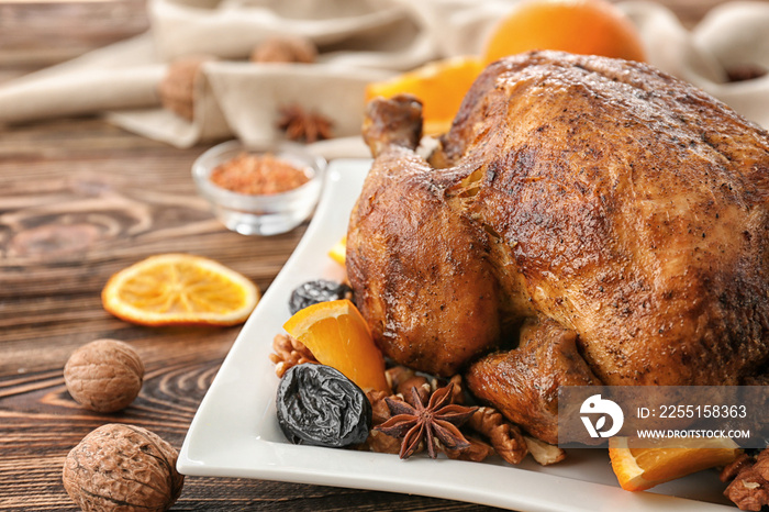 Tasty roasted turkey with slices of orange and prune on plate