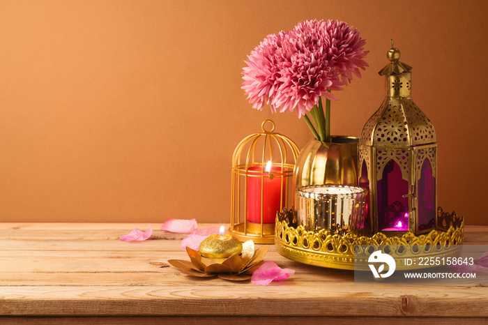 Diwali holiday candles and lantern on wooden table.