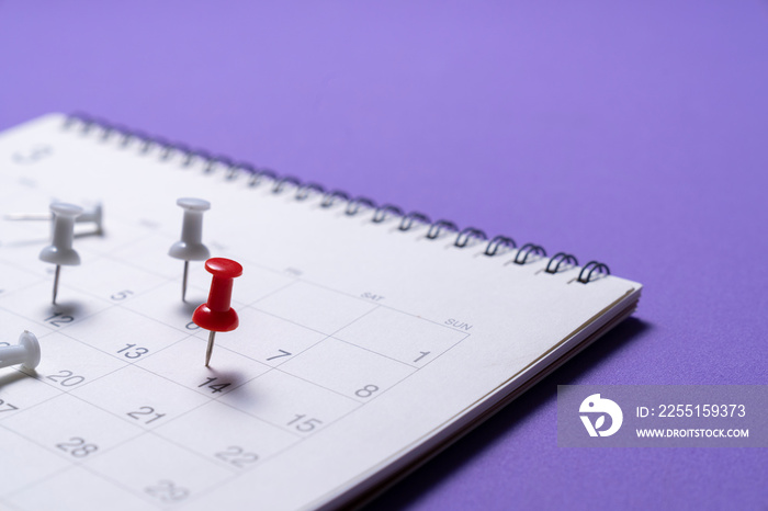 close up of pin and calendar on the purple table background, planning for business meeting or travel planning concept