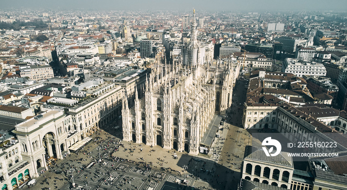 Aerial view of Piazza Duomo in front of the gothic cathedral in the center. Drone view of the gallery and rooftops during the day. Milan, Italy. High quality photo