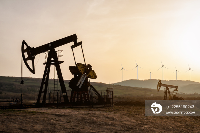 oil pumps and electric windmills at sunset