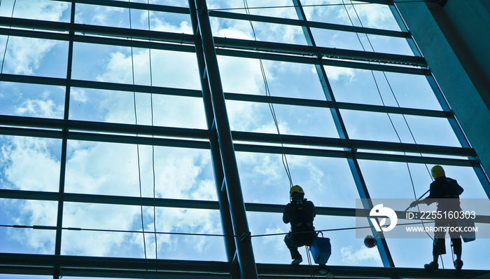 Extreme work. Cleaning the glass of a building at a height takes courage and challenges adrenaline