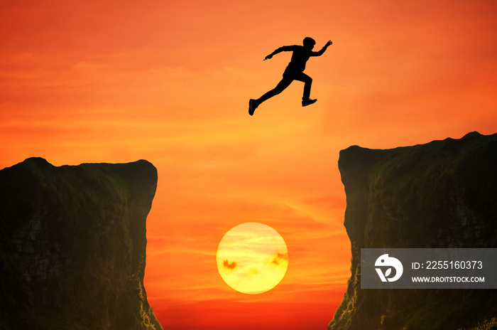 man jumping over the cliff, silhouette