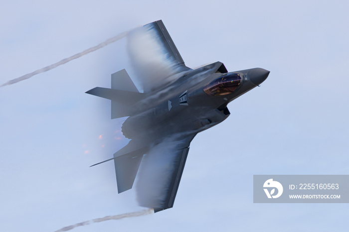 Very unusual close view of a F-35C  in a high G maneuver , with condensation clouds over the wings and afterburner on