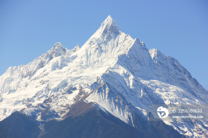 Kawagarbo snow mountain on a blue sky in Deqin, Yunnan province, China. Summit, peak of sharp snowcapped mountain. Unreachable, challenge concept