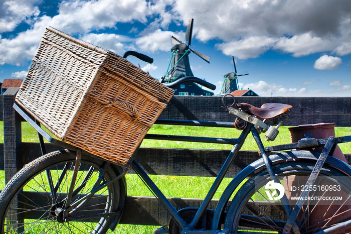 Bicycle with windmill and blue sky background. Scenic countryside landscape close to Amsterdam in the Netherlands.