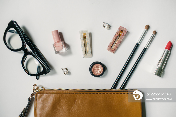 Shadows, Brushes, glasses, brushes, pomade on white background. The contents of women’s handbags. Make up bag with cosmetics. Flat lay