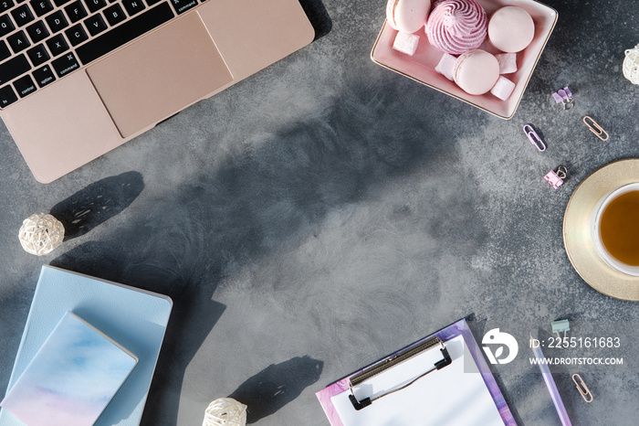 Top view of stylish workplace on gray textured background with sunlight and shadows. Flat lay of home desk with sun light.