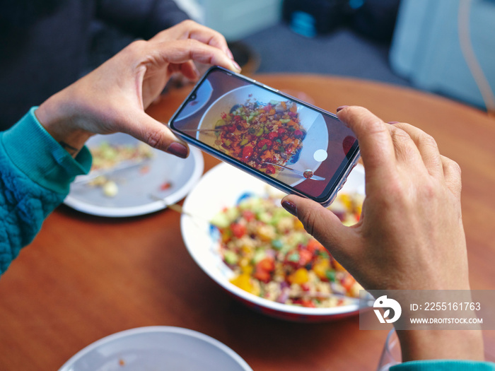 Woman taking picture of lunch with smart phone