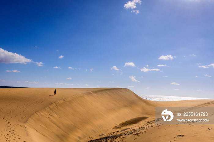 woman walking on dunes in maspalomas, spain