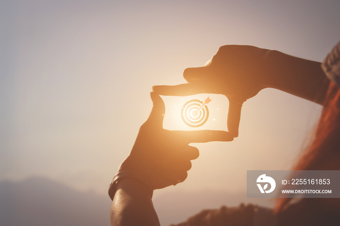 Planning and vision concept of new year’s start, woman hands making frame gesture find focus at sunset, woman looking for perspective to capture the meaning of a clear upcoming target.