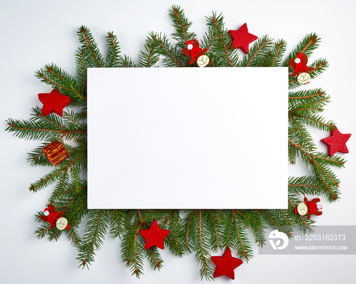 congratulatory Christmas background with an empty white sheet and green branches of spruce