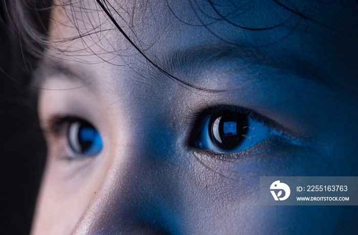 Little girl eyes looking at monitor, Monitor blue light is reflected in her eyes,effects on the eyes.