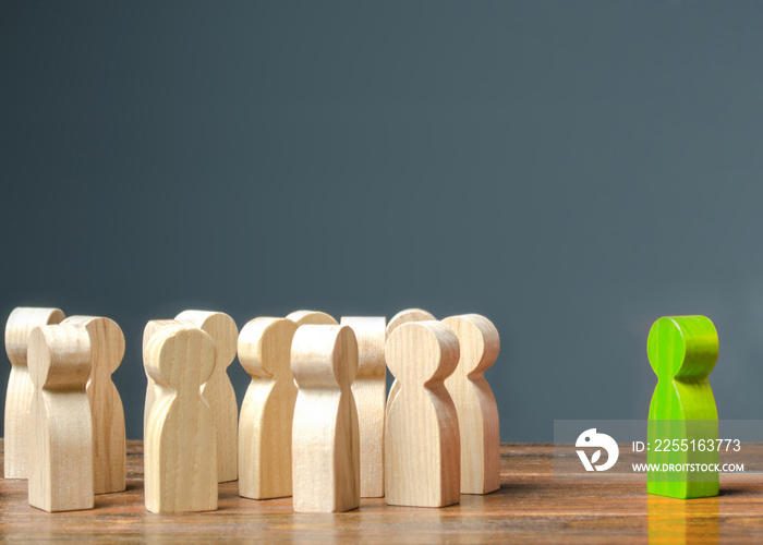 green figurine of a man stands near the crowd of people. Development of leadership and social qualities. cooperation. Leader and leadership, coordination, Social connections, communication.