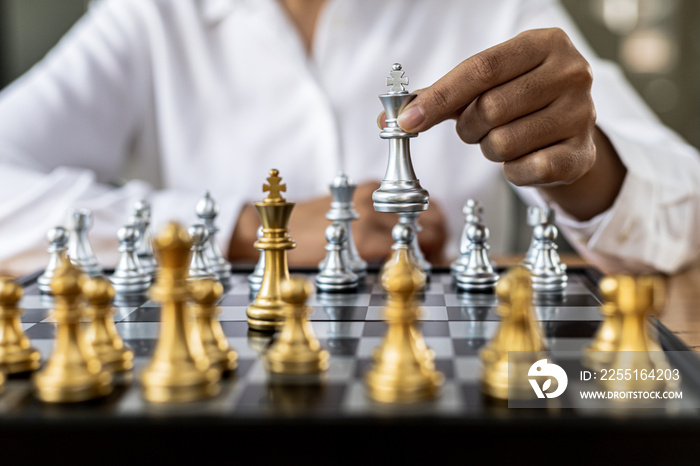 Person playing chess board game, business woman concept image holding chess pieces like business competition and risk management, planning business strategies to defeat business competitors.