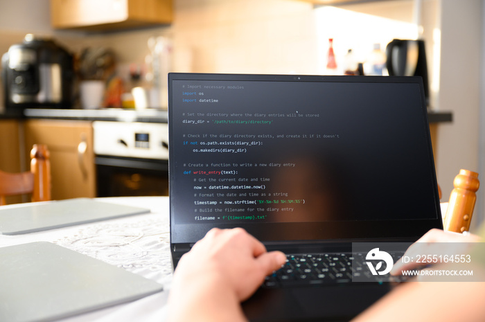 Coding in the house, a woman writing code on a laptop for an app or website while working from home