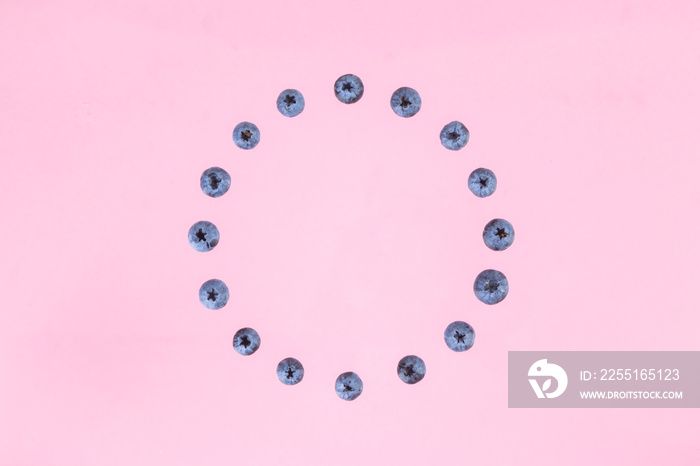 Berries of blueberries arranged in a circle. Pink background. Concept of berries season and proper nutrition.