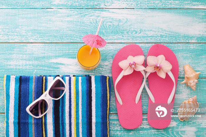 Summer background. Trendy summer accessories on wooden background. Flip-flops on beach. Tropical flower orchid. Flat mock up for design.