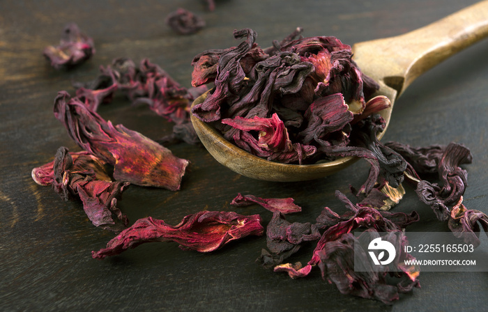 dry hibiscus petals in a wooden spoon. close up