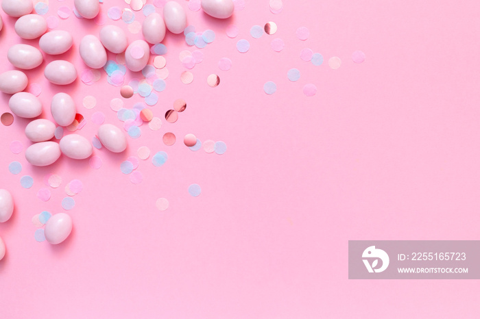 Bunch of candy eggs on pink background. Minimal Easter concept with copy space for text. Festive day backdrop. Flat lay style with minimalistic design.