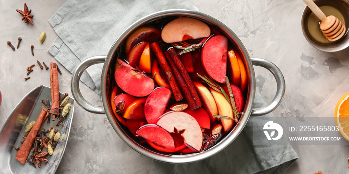 Saucepan of delicious mulled wine on table, top view